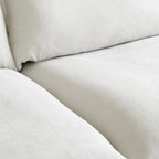 Divano componibile a L a 5 posti bianco/beige/nero, con poggiapiedi opzionale